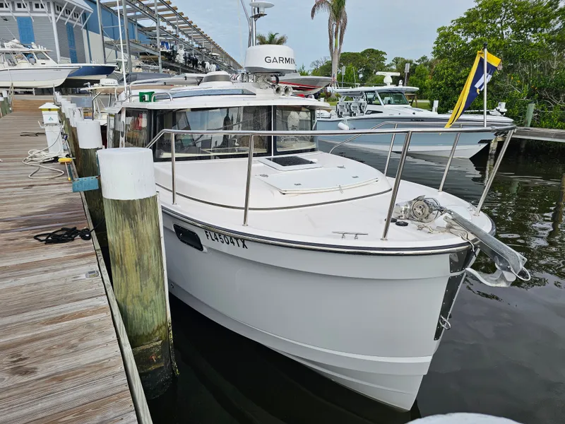 Slide: The Image of A white 2025 Ranger Tugs R-27 boat docked at a wooden pier. - 10