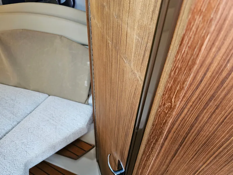Slide: The Image of Interior of a 2025 Ranger Tugs R-27 with wooden doors and upholstered seating. - 21