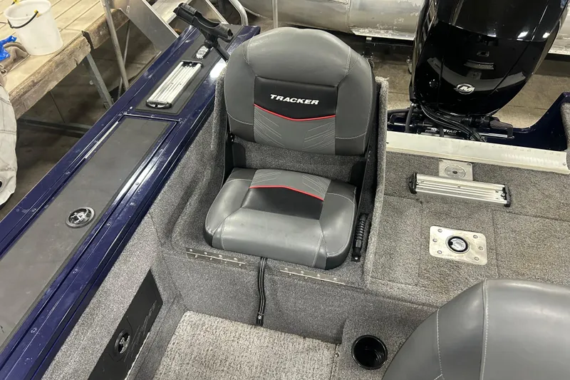Slide: The Image of 2024 Tracker Targa V-18 Combo boat interior with cushioned seat and motor view. - 13