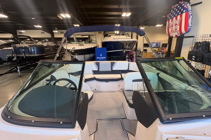 Slide: The Image of 2027 Regal 2000 ES boat interior in showroom, featuring seating and steering wheel. - 19