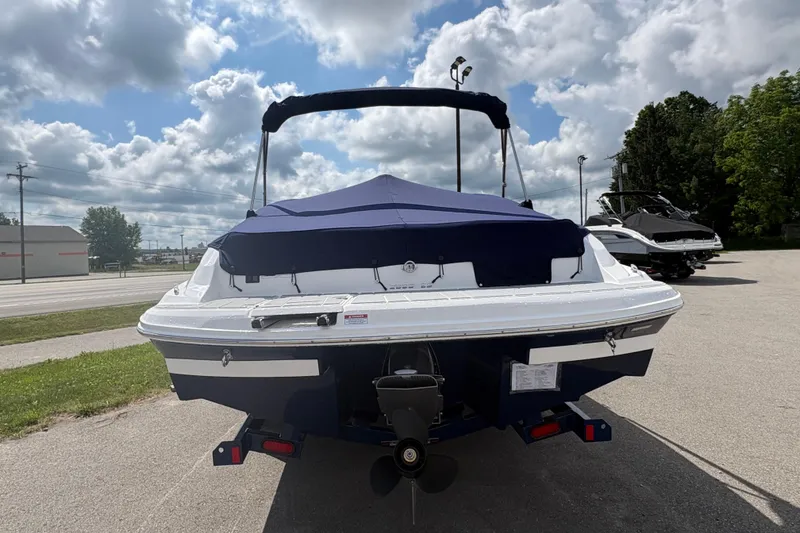 Slide: The Image of 2027 Regal 2000 ES boat with blue cover, parked outdoors under cloudy sky. - 22