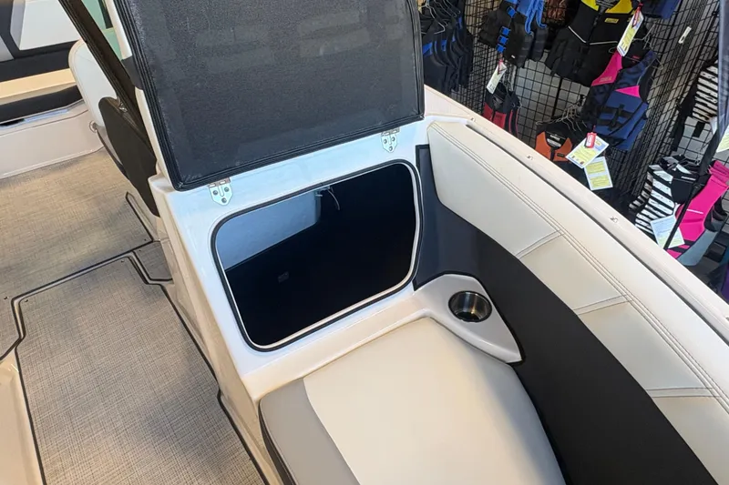 Slide: The Image of Open storage compartment in a 2027 Regal 2000 ES boat interior, showcasing seating and cup holder. - 17