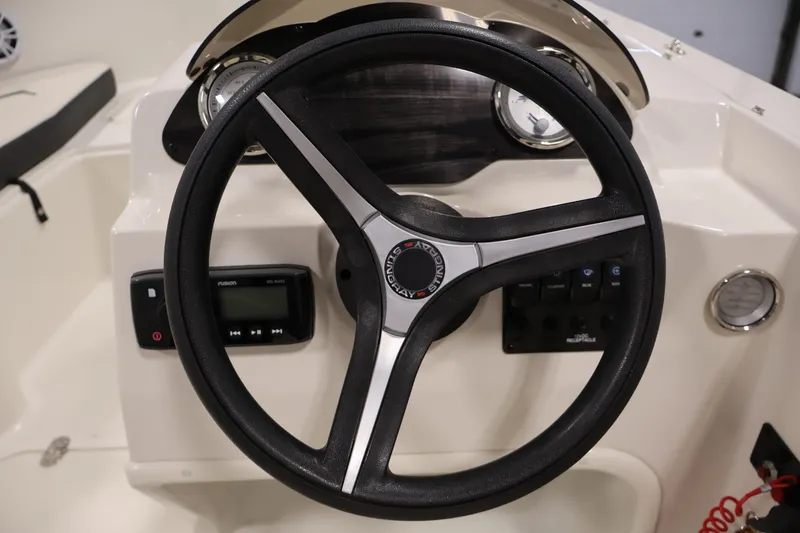 Slide: The Image of Steering wheel of a 2021 Stingray 172 SC boat with dashboard controls. - 19