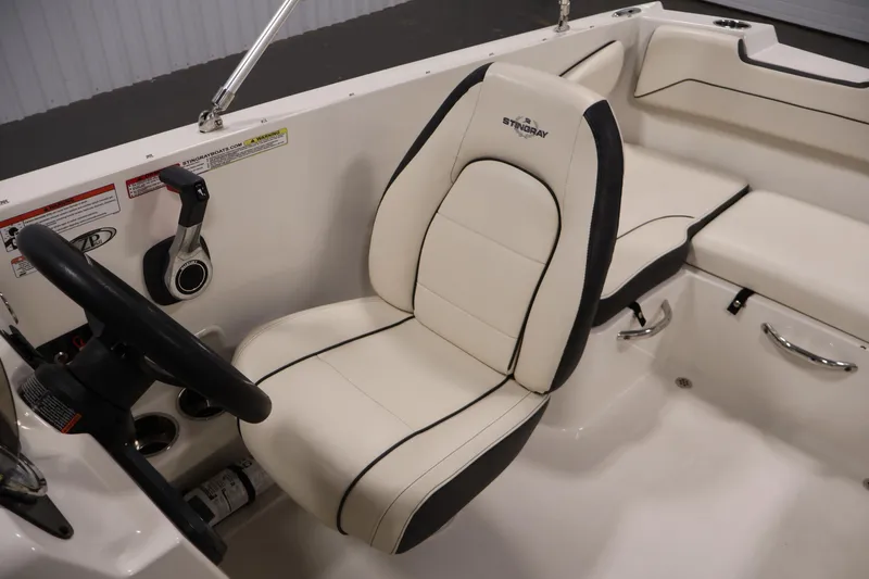 Slide: The Image of 2021 Stingray 172 SC boat interior with white seating and steering wheel. - 27