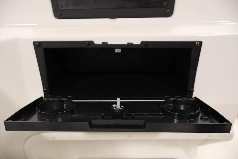 Slide: The Image of Open storage compartment with cup holders in a 2021 Stingray 172 SC boat. - 29
