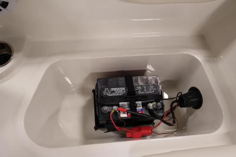 Slide: The Image of Battery compartment of a 2021 Stingray 172 SC boat, featuring a secured battery. - 36
