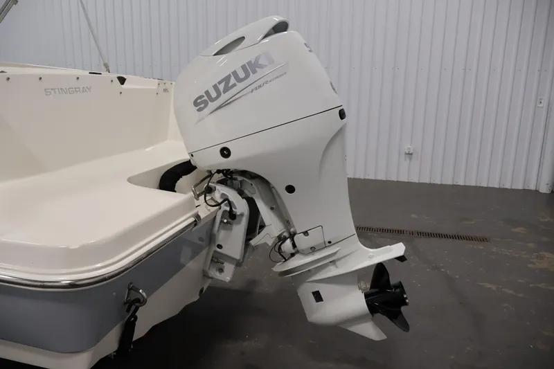 Slide: The Image of 2021 Stingray 172 SC boat with Suzuki outboard motor in a garage setting. - 38