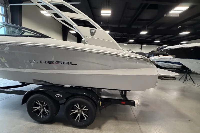 Slide: The Image of 2027 Regal LS2 boat on trailer in showroom, sleek design, modern features. - 3