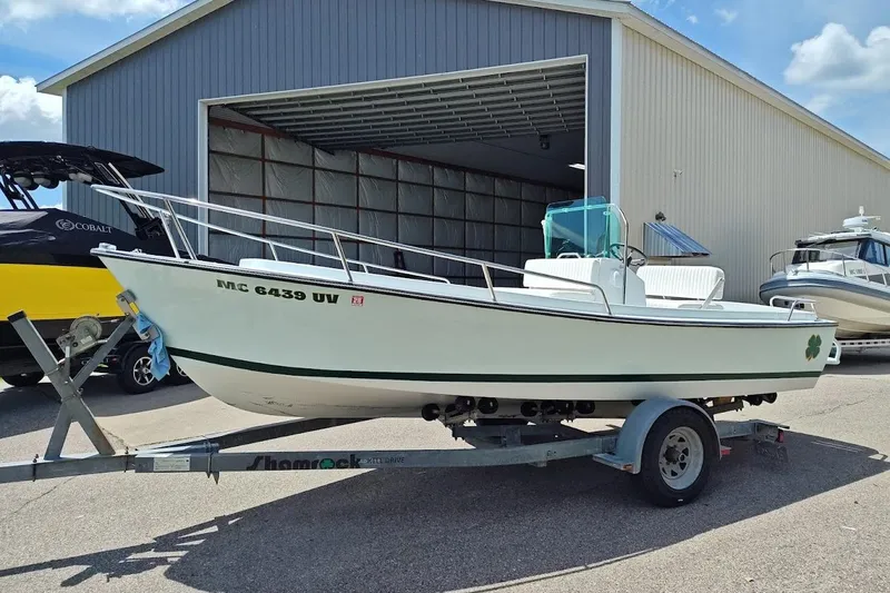 The Image of 1975 Shamrock 200 Open boat on trailer outside a large storage building. - 1