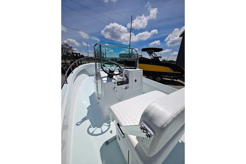 Slide: The Image of 1975 Shamrock 200 Open boat interior with steering wheel and seating under a blue sky. - 4