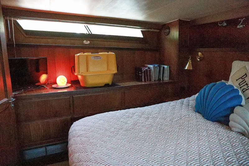 Slide: The Image of Cozy cabin interior of 1987 Hatteras 40 Double Cabin with bed, TV, and decorative pillows. - 48