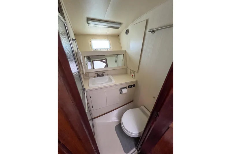 Slide: The Image of 1987 Hatteras 40 Double Cabin bathroom with sink, toilet, and mirror. - 34