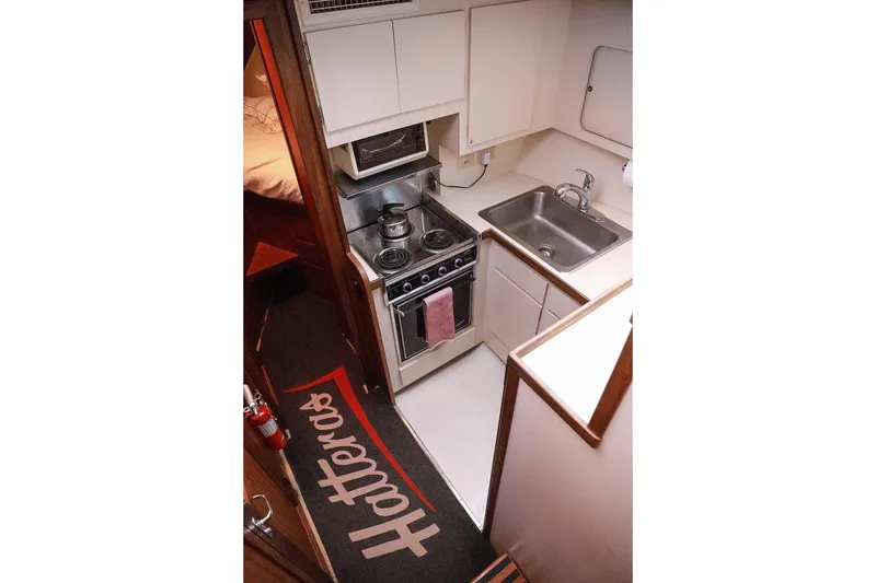 Slide: The Image of Compact kitchen in 1987 Hatteras 40 Double Cabin yacht with stove, sink, and cabinetry. - 52