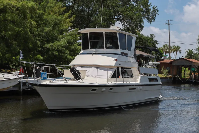 Slide: The Image of 1987 Hatteras 40 Double Cabin yacht cruising on a serene waterway. - 9