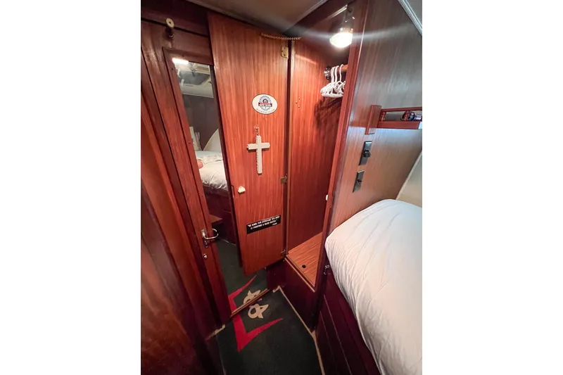 Slide: The Image of 1987 Hatteras 40 Double Cabin interior with wooden paneling and cozy bedding. - 32
