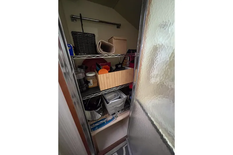 Slide: The Image of Storage shelves with various items inside a 1987 Hatteras 40 Double Cabin boat. - 36