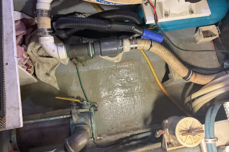 Slide: The Image of Engine room of 1987 Hatteras 40 Double Cabin with visible hoses and fittings. - 18