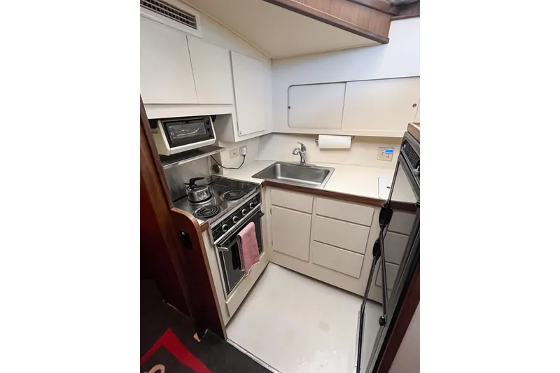 Slide: The Image of Compact kitchen in 1987 Hatteras 40 Double Cabin yacht with stove, sink, and storage. - 42