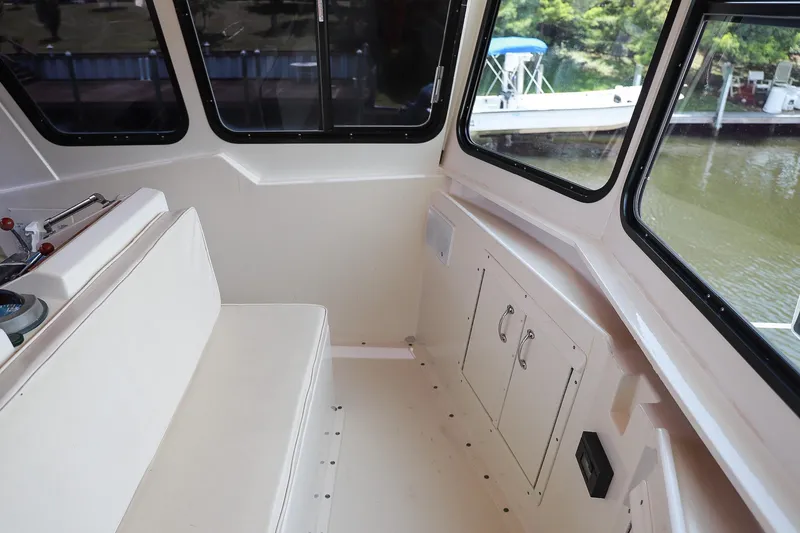 Slide: The Image of 1987 Hatteras 40 Double Cabin interior with seating and windows overlooking water. - 64