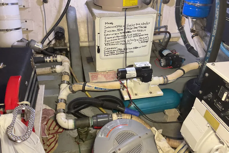 Slide: The Image of Engine room of 1987 Hatteras 40 Double Cabin with various mechanical components and maintenance notes. - 14