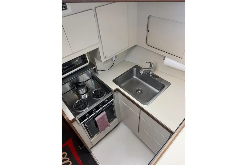 Slide: The Image of Compact kitchen area in a 1987 Hatteras 40 Double Cabin yacht with stove and sink. - 41