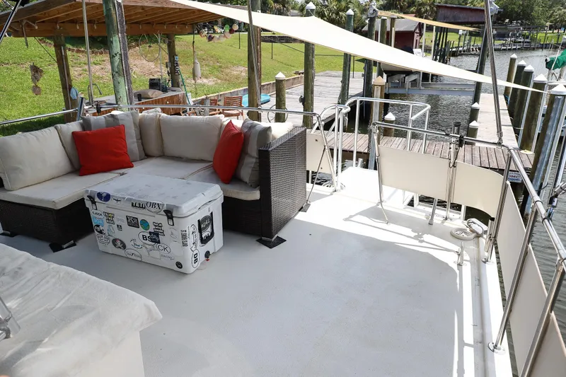 Slide: The Image of 1987 Hatteras 40 Double Cabin yacht deck with seating, cooler, and dock view. - 12