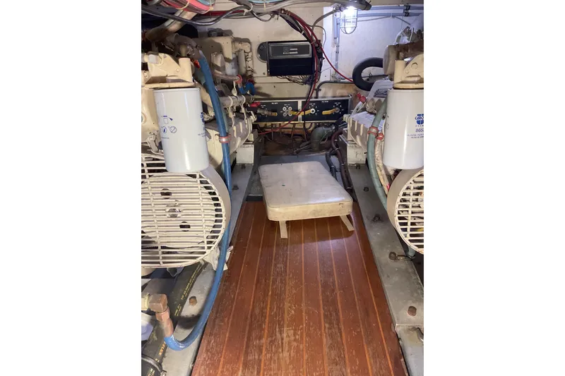 Slide: The Image of Engine room of 1987 Hatteras 40 Double Cabin yacht, featuring dual engines and control panel. - 23