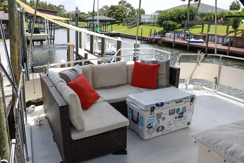 Slide: The Image of 1987 Hatteras 40 Double Cabin yacht deck with wicker seating and cooler. - 13