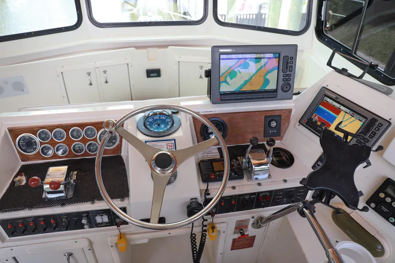Slide: The Image of Helm of 1987 Hatteras 40 Double Cabin with navigation equipment and steering wheel. - 59