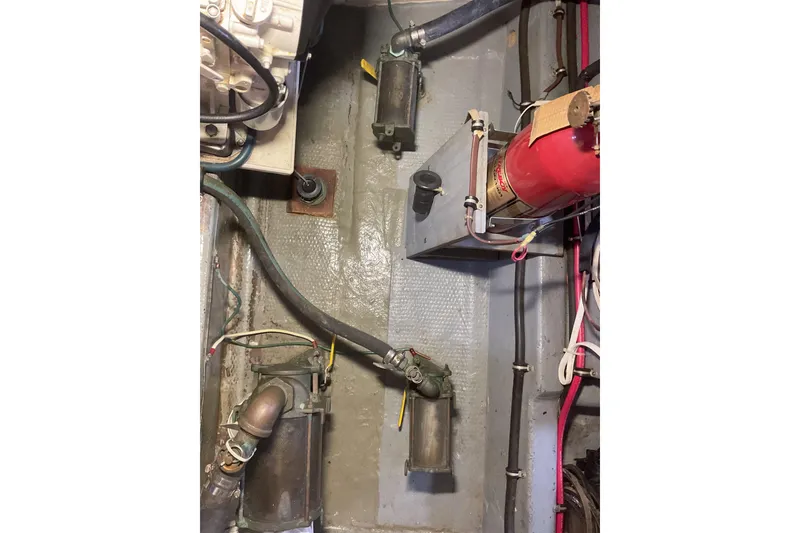 Slide: The Image of Engine room of 1987 Hatteras 40 Double Cabin with visible fire extinguisher and piping. - 21