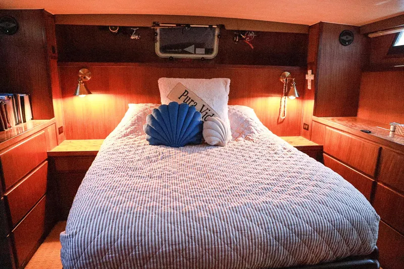 Slide: The Image of Cozy cabin bedroom in 1987 Hatteras 40 Double Cabin yacht with striped bedding and soft lighting. - 45