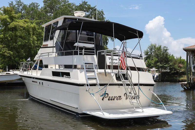 Slide: The Image of 1987 Hatteras 40 Double Cabin yacht docked on a sunny day, featuring a sleek design. - 7