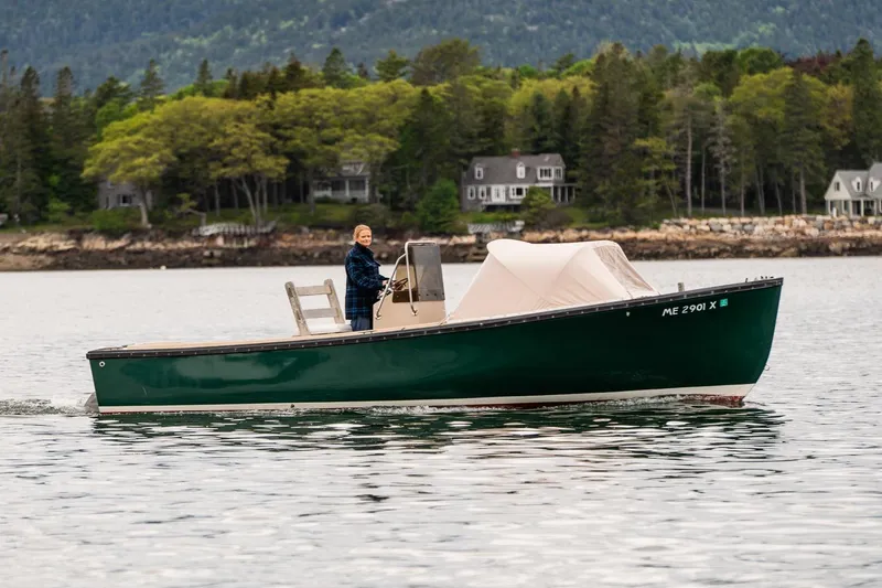 Slide: The Image of 1989 Ellis 24 Open boat cruising on a scenic lake with forested shoreline. - 10