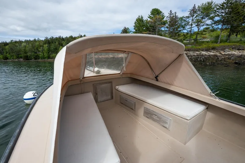 Slide: The Image of 1989 Ellis 24 Open boat interior with canopy, featuring cushioned seating and scenic water view. - 29