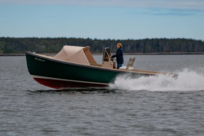 Slide: The Image of 1989 Ellis 24 Open boat cruising on a lake with a person steering. - 7