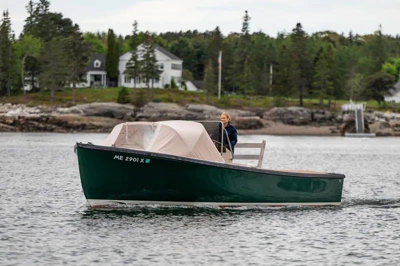 Slide: The Image of 1989 Ellis 24 Open boat cruising on a scenic lake with a forested shoreline. - 15