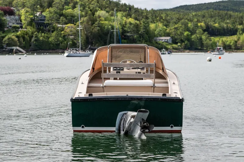 Slide: The Image of 1989 Ellis 24 Open boat on calm water, surrounded by lush greenery. - 23