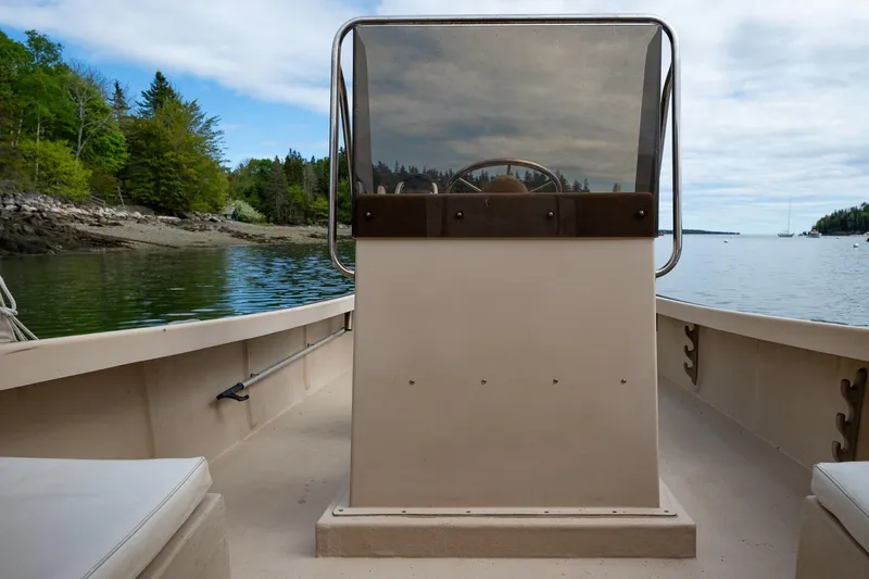 Slide: The Image of 1989 Ellis 24 Open boat on calm water, surrounded by lush greenery and a clear sky. - 33