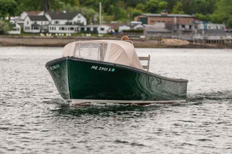 Slide: The Image of 1989 Ellis 24 Open boat cruising on calm water near shoreline houses. - 16