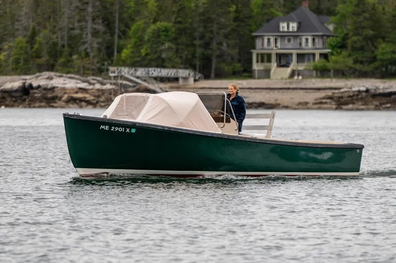 Slide: The Image of 1989 Ellis 24 Open boat cruising near a shoreline with a house in the background. - 14