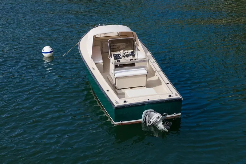 Slide: The Image of 1989 Ellis 24 Open boat on water, featuring a sleek design and outboard motor. - 21