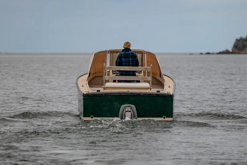 Slide: The Image of A person navigates an Ellis 24 Open boat from 1989 on calm waters. - 13