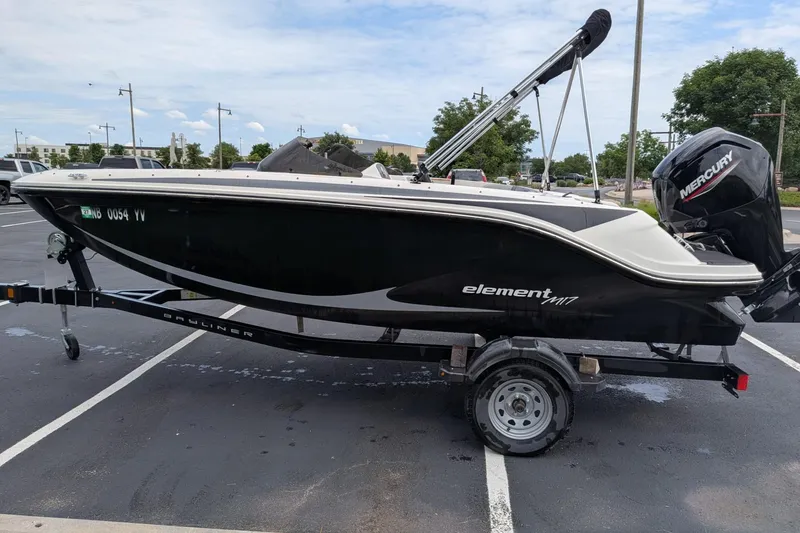 The Image of 2023 Bayliner Element M17 boat on trailer in parking lot, side view. - 1