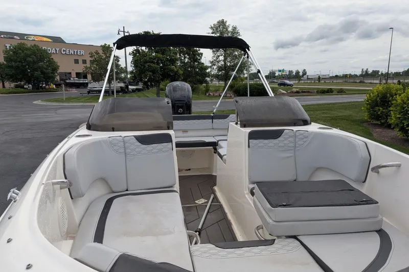 Slide: The Image of 2023 Bayliner Element M17 boat interior with seating, parked near a boat center. - 5