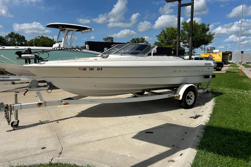 Slide: The Image of 1999 Bayliner 1954 Capri boat on trailer under a clear blue sky. - 8
