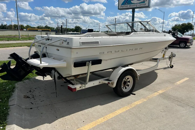 Slide: The Image of 1999 Bayliner 1954 Capri boat on trailer, parked outdoors under a cloudy sky. - 4
