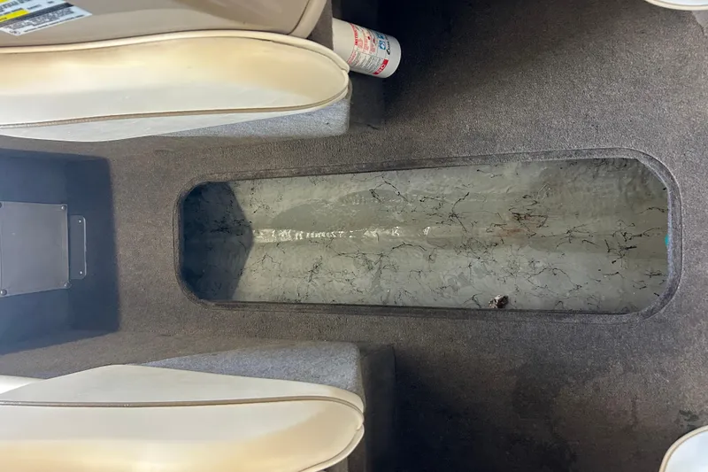 Slide: The Image of Interior view of a 1999 Bayliner 1954 Capri boat, showing storage compartment. - 23