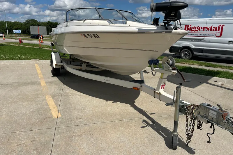 Slide: The Image of 1999 Bayliner 1954 Capri boat on trailer in parking lot under blue sky. - 9