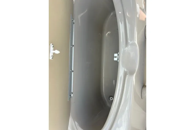 Slide: The Image of Storage compartment of a 1999 Bayliner 1954 Capri boat, featuring a beige interior. - 15
