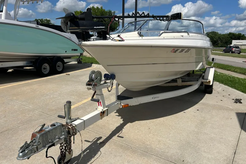 Slide: The Image of 1999 Bayliner 1954 Capri boat on trailer, parked outdoors under a cloudy sky. - 6